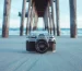 กล้องฟิล์ม Canon AE-1 วางบนพื้นทรายริมน้ำ
