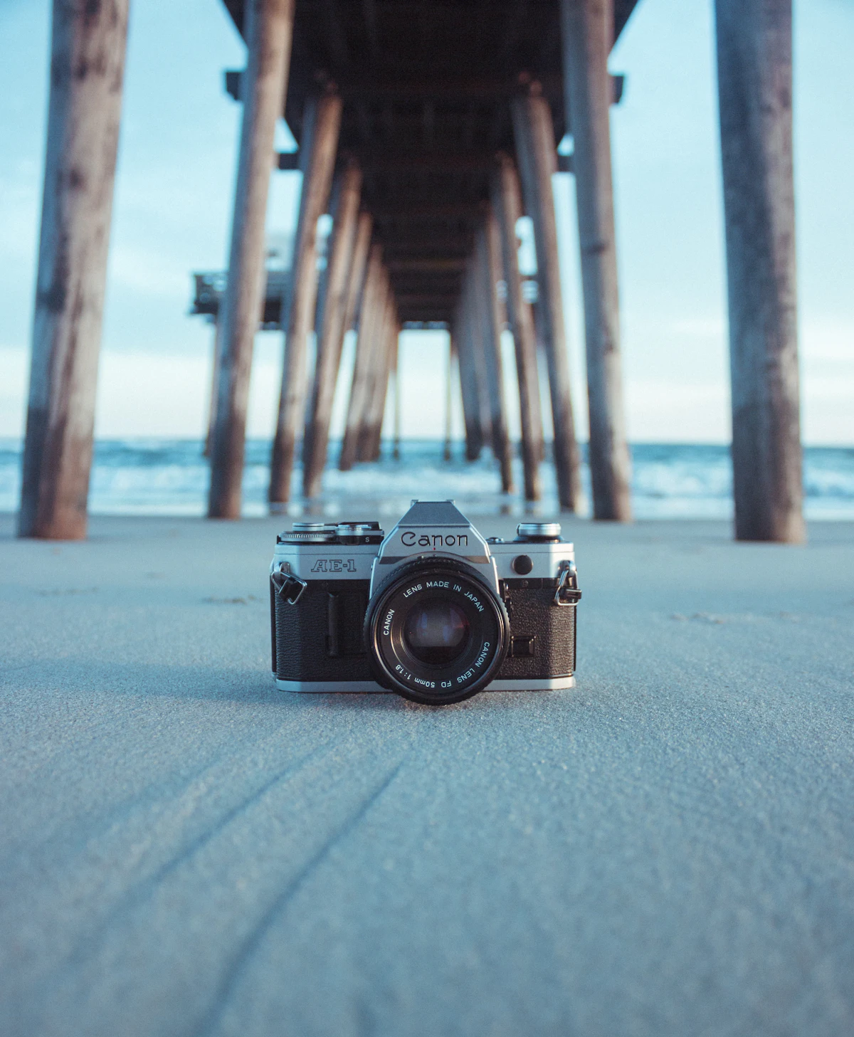 กล้องฟิล์ม Canon AE-1 วางบนพื้นทรายริมน้ำ