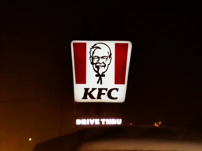 ป้ายไฟ KFC ส่องสว่างยามค่ำคืน โลโก้ตัวอักษรและภาพผู้พันแซนเดอร์ส