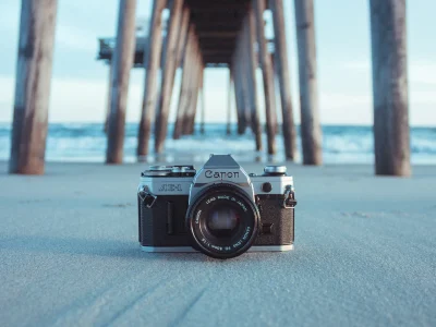 กล้องฟิล์ม Canon AE-1 วางบนพื้นทรายใต้แสงกลางแจ้ง