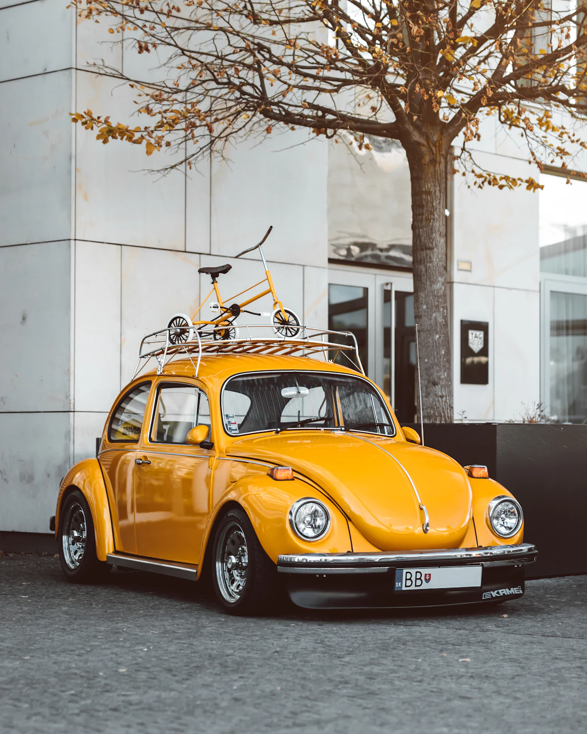 รถ Volkswagen Beetle สีเหลือง รถที่ผูกกับโฆษณายุคที่ใช้ฟอนต์ Futura
