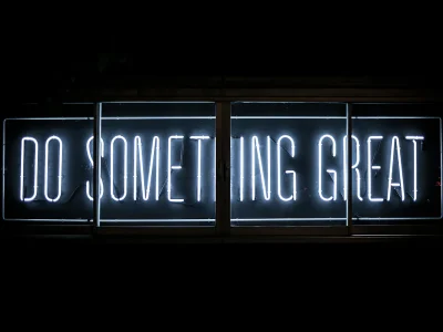ป้ายนีออนคำว่า Do Something Great บนผนังมืด